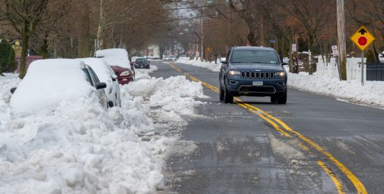 cars covered in snow, parked in street