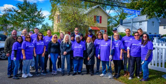 Supervisor Carpenter stands side by side ith members of the First Baptist church and volunteers infront of one of the spruced up homes.