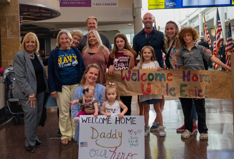 Supervisor and family group photo with welcome home signs