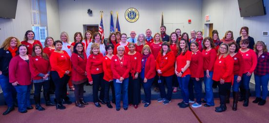 Town Supervisor Angie Carpenter and 50 of Town of Islip employees pose for a photo, wearing read in support of the movement.