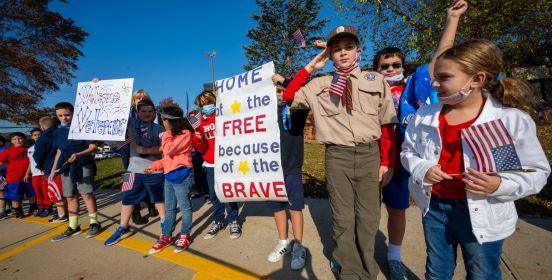 kids salute veterans with signs