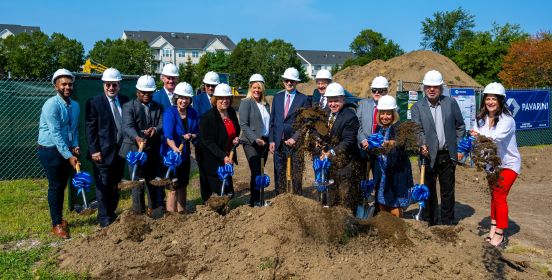 Supervisor Carpenter and other elected officials posing for a group shot, all with hardhats on and holding shovels with upturned ground soil.