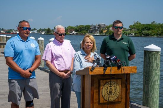 Supervisor at Podium at Presser with experts to her left and right