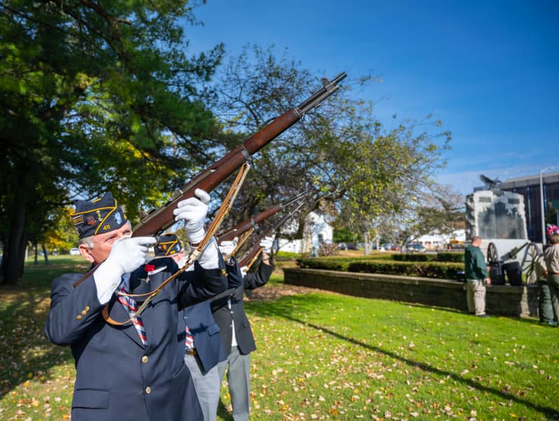 Rifles held up by Veterans as part of gun salute
